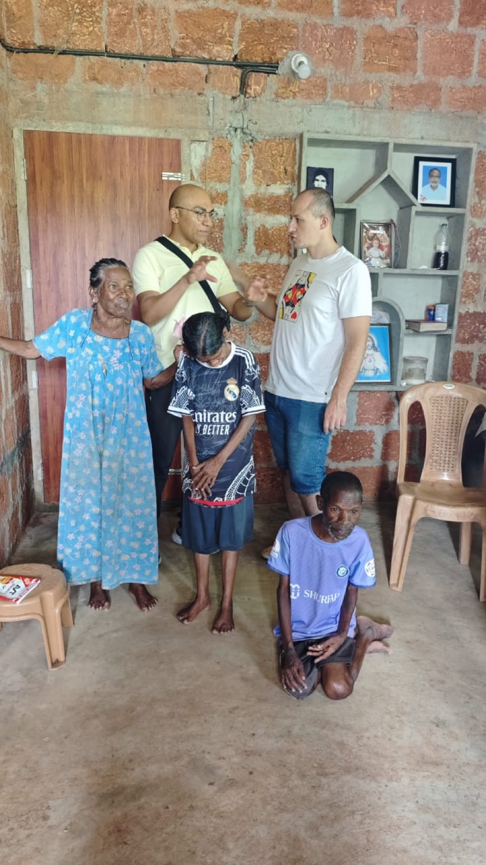 Kneeling in prayer beside a grandmother, in her own home.