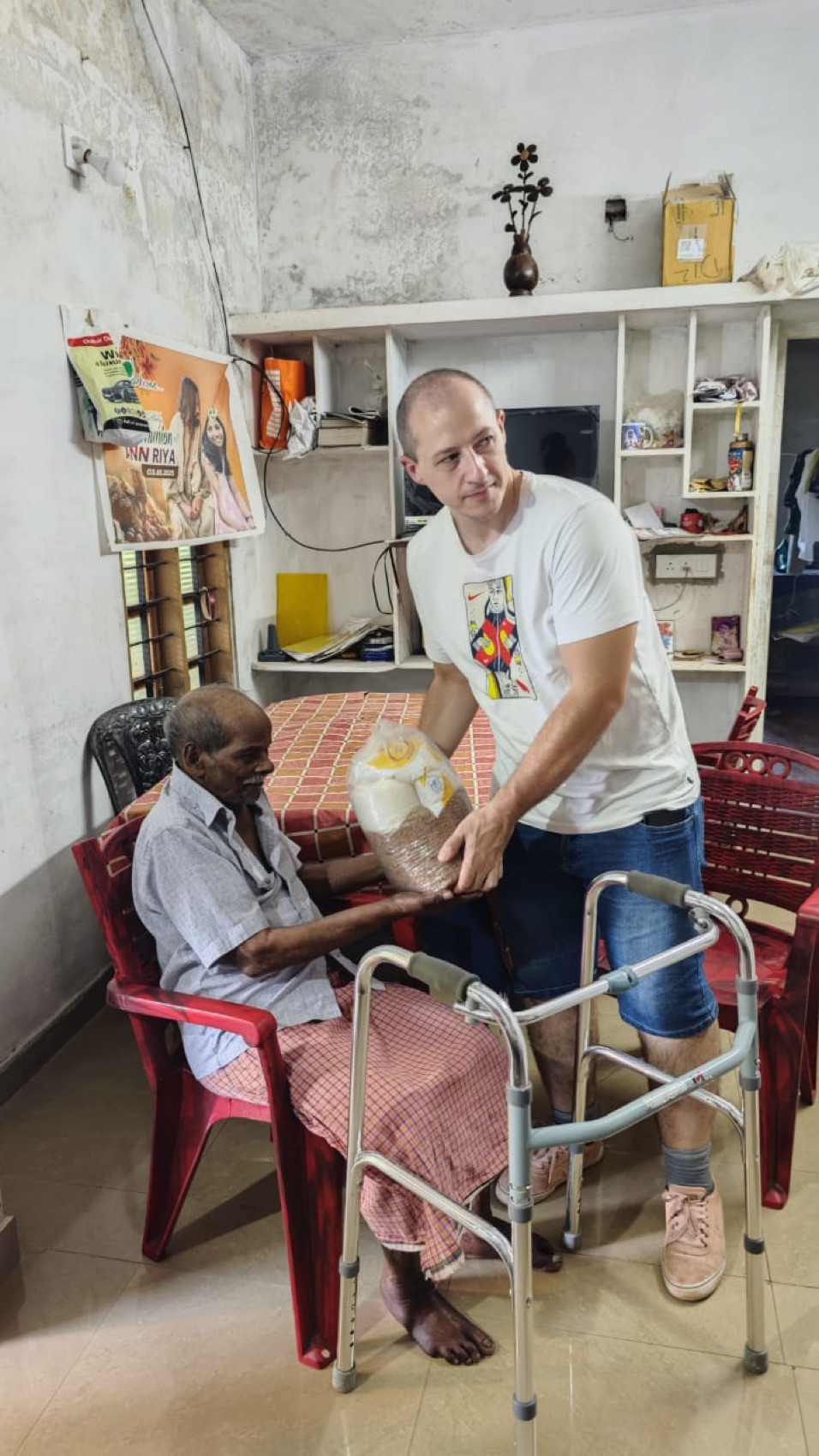 A volunteer from overseas carries provisions to an elderly neighbour.
